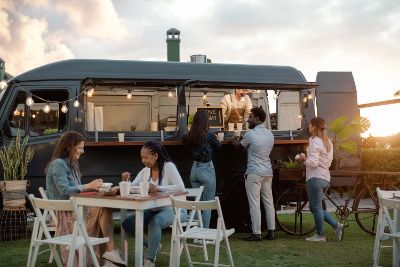 Fröhliche Menschen haben Spaß beim Essen in einem Street Food Truck Markt